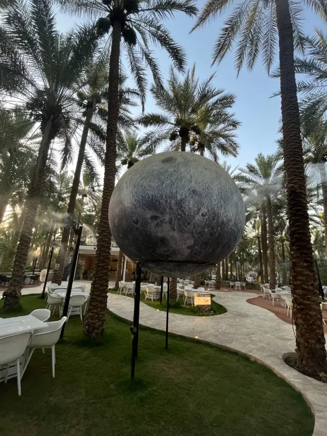 A moon sculpture among the palm trees at Palms Avenue in Unaizah